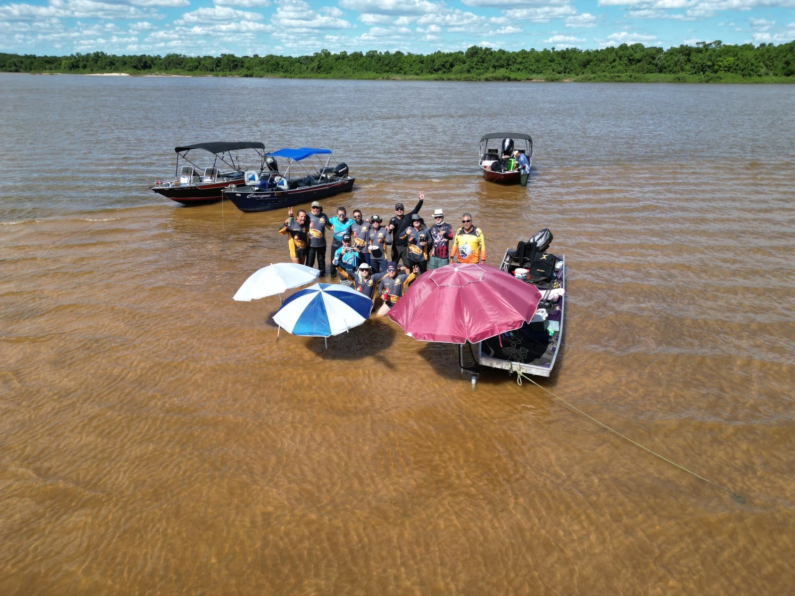 Grupo de pescadores pescando na água com guarda-sóis