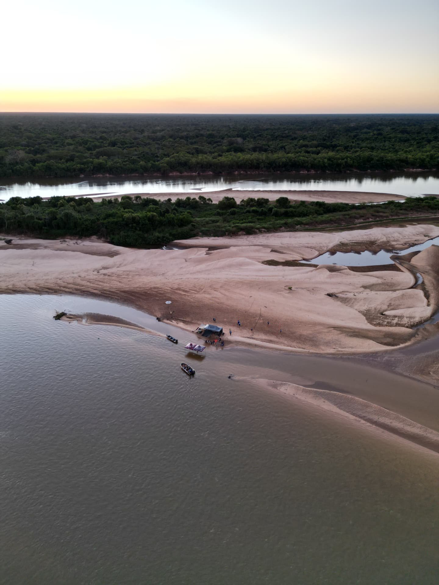 Aéreo do acampamento de praia ao pôr do sol